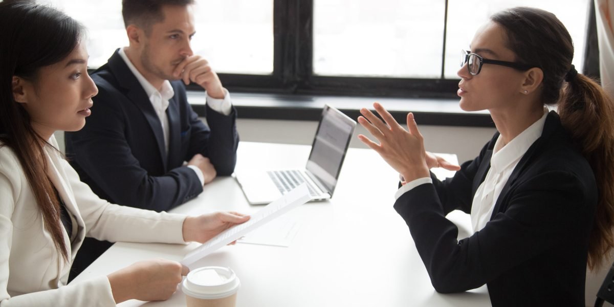 Confident female job applicant talking about experience, expressing thoughts and ideas, HR managers looking suspicious, not liking candidate, doubting, judging. Concept of recruitment stress interview