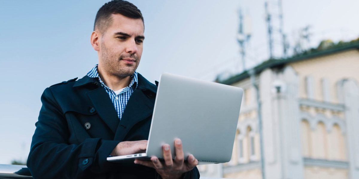 man-using-laptop-urban-environment man-using-laptop-urban-environment